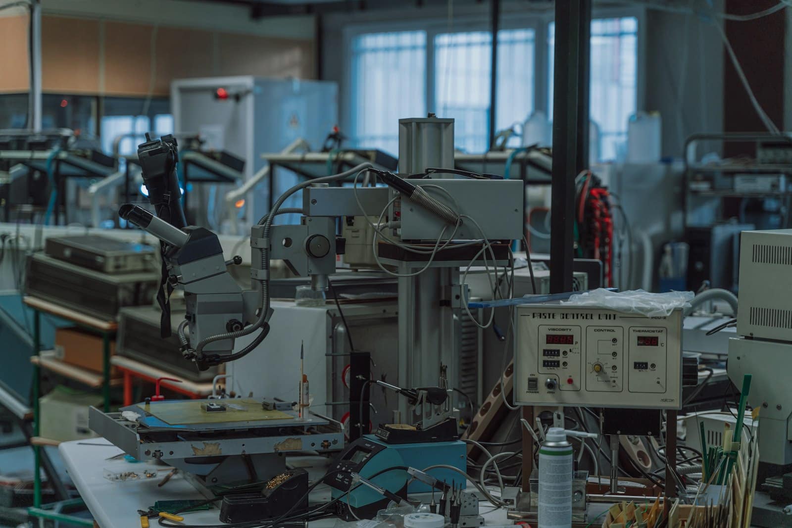 Moulding and control equipment on a factory floor, gauges and machines in muted light