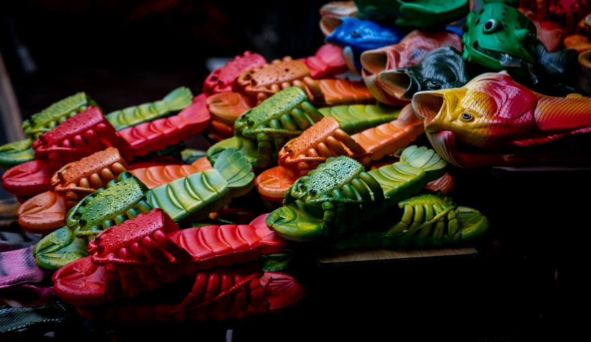 Moulded sandals in mixed colours piled together, one run of a seasonal order